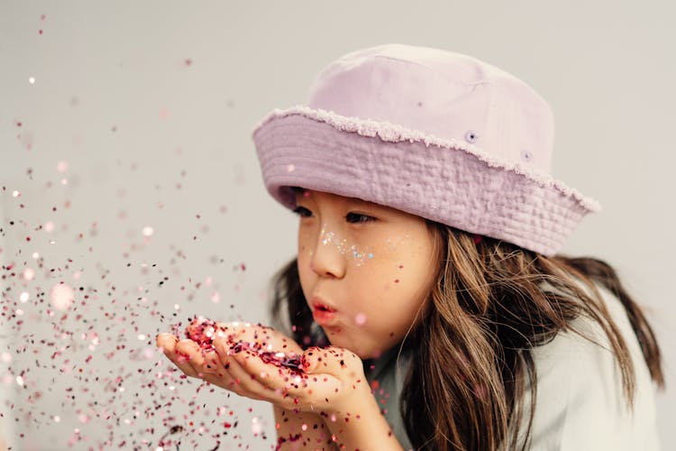 A Girl Blowing Confetti