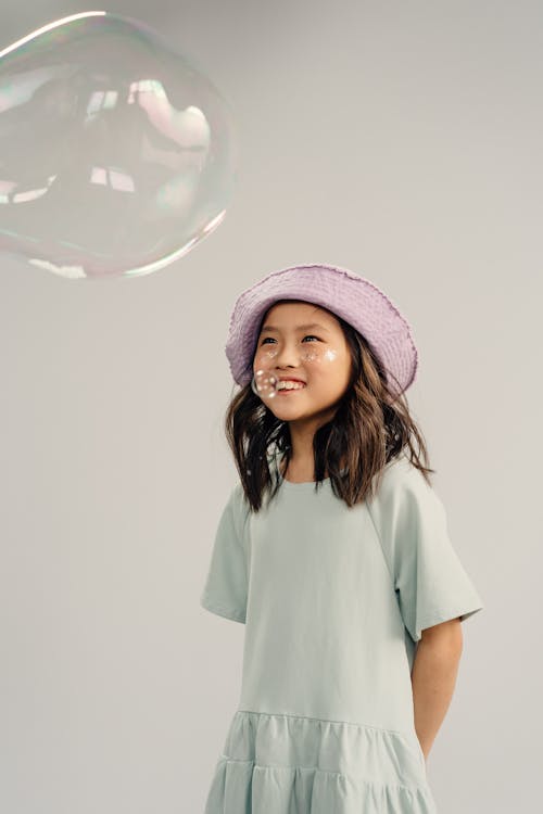 Young Girl Playing Bubbles on White Background