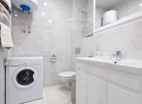 Free Bright minimalist bathroom featuring a washing machine and modern fixtures. Stock Photo