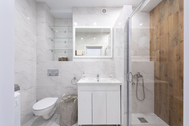 Fully furnished modern bathroom with marble tiles and glass shower