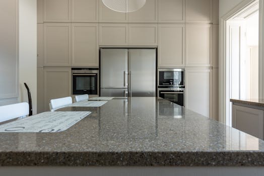 Sleek modern kitchen featuring granite countertops and stainless steel appliances.