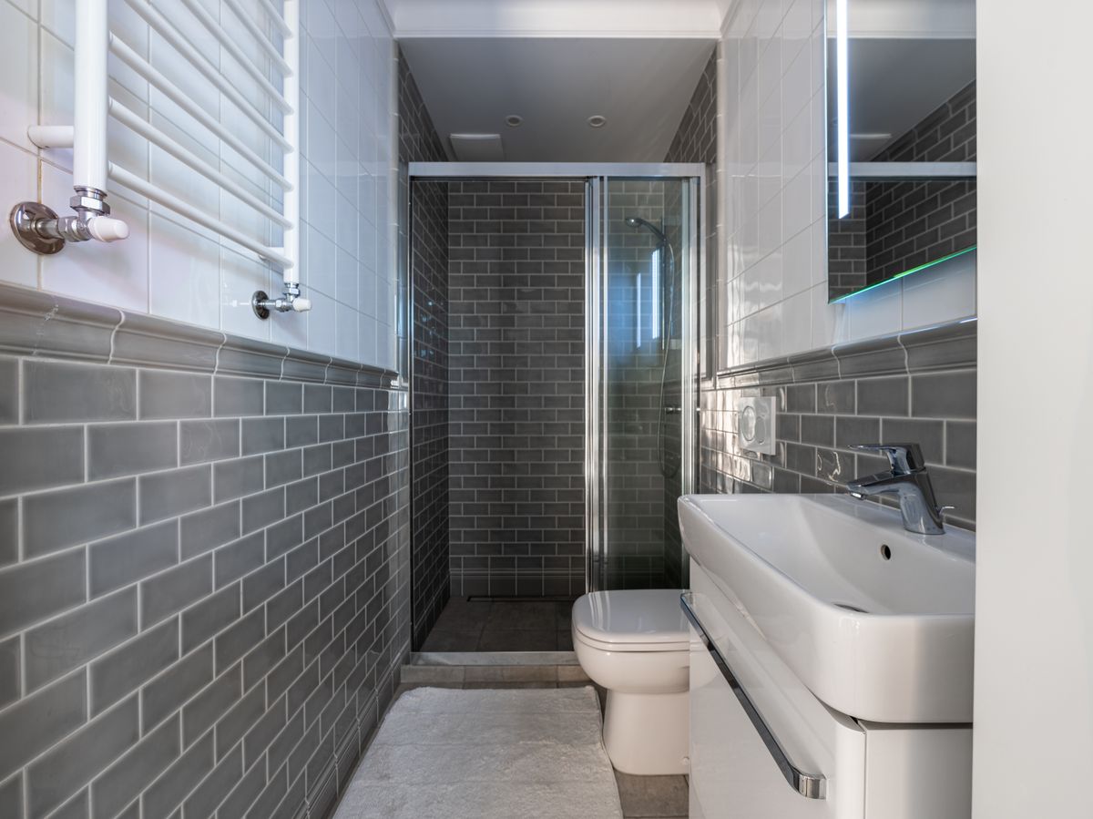Neu saniertes Badezimmer mit bodengleicher Dusche und hellen Fliesen