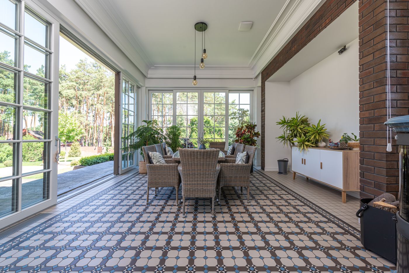 Bright sunroom with wicker chairs and a patterned tile floor