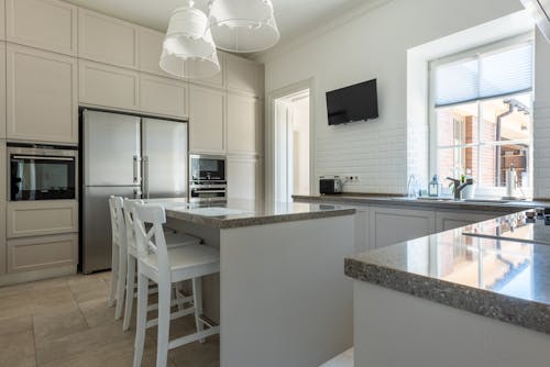White Pendant Lamps Over Granite Kitchen Counter