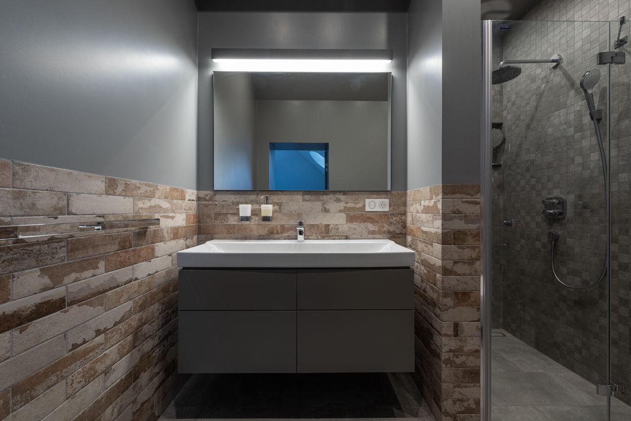 Modern bathroom with wall-hung vanity sink and glass-enclosed shower