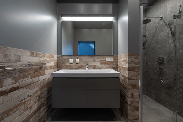 Contemporary bathroom with glass shower and illuminated mirror