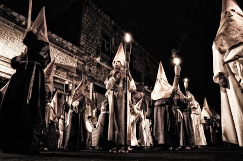 A  Parade of People in Costumes Holding Torches