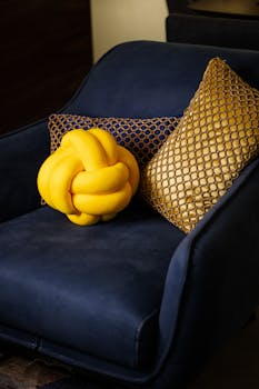 Blue chair with elegant gold and yellow cushions in a stylish interior setting.
