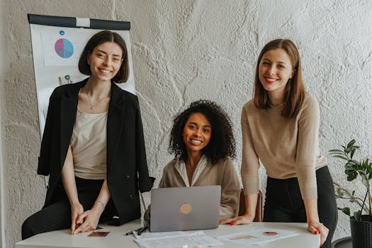Diverse group of women engaged in a business meeting, smiling and collaborating.