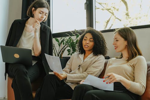 Free Women Sitting on a Sofa While Talking Business Stock Photo