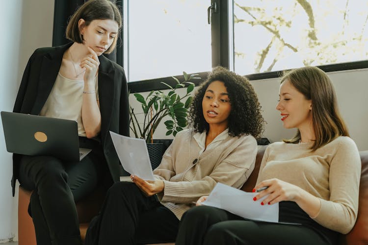 Women Sitting On A Sofa While Talking Business