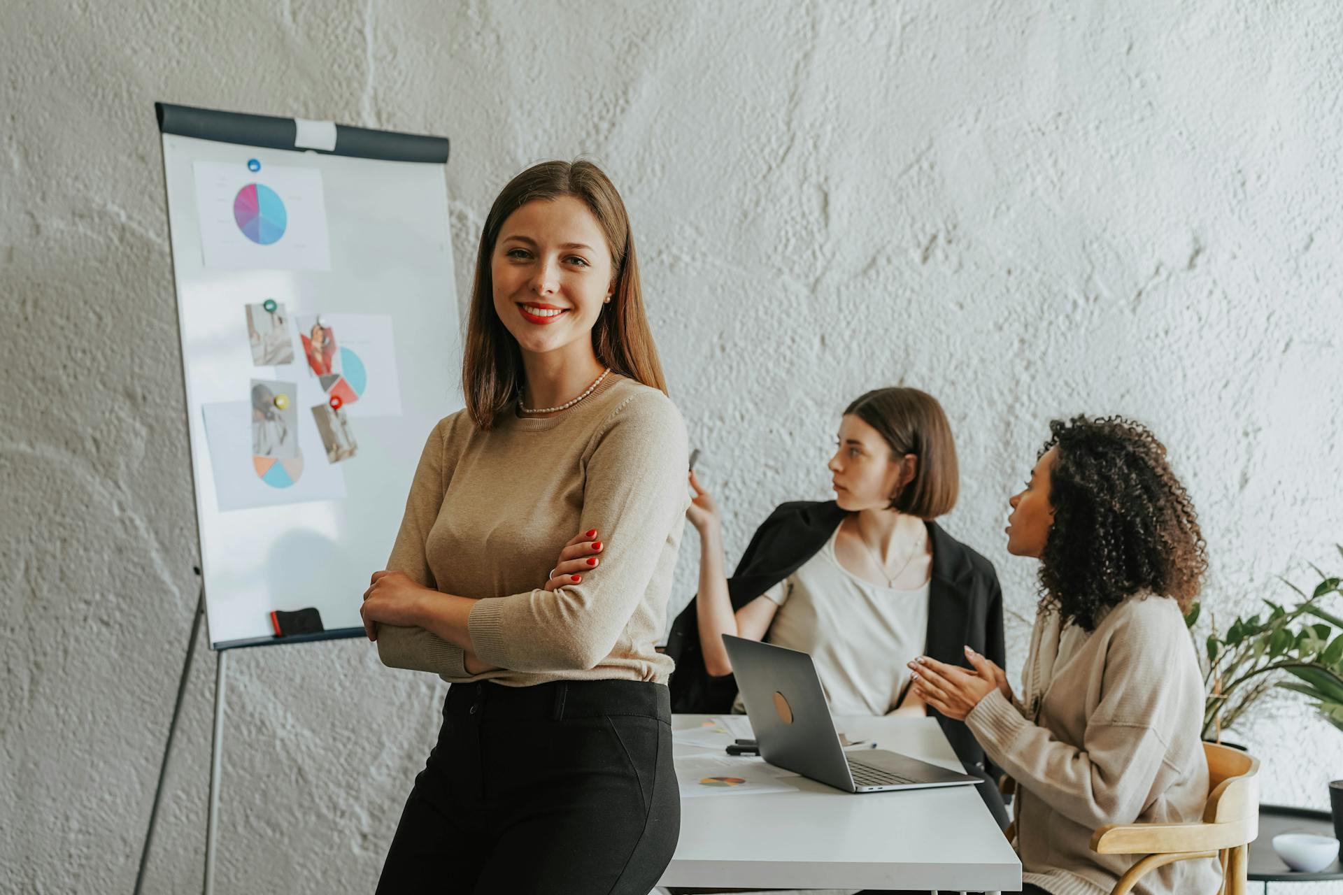 A confident leader stands in front of a diverse team during a business meeting.