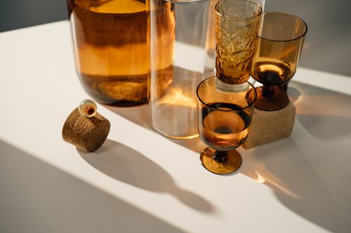 Free A stylish arrangement of amber glassware casting shadows on a white surface. Stock Photo