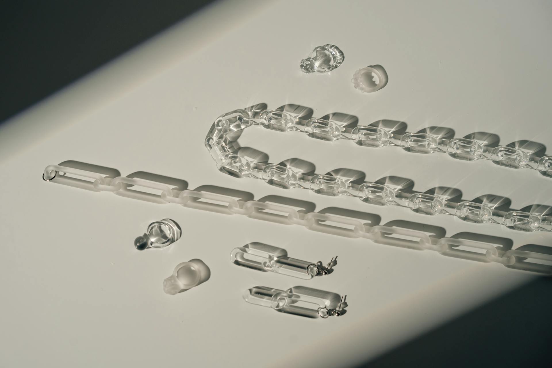 A captivating minimalist still life featuring transparent plastic chains stylishly arranged on a table.