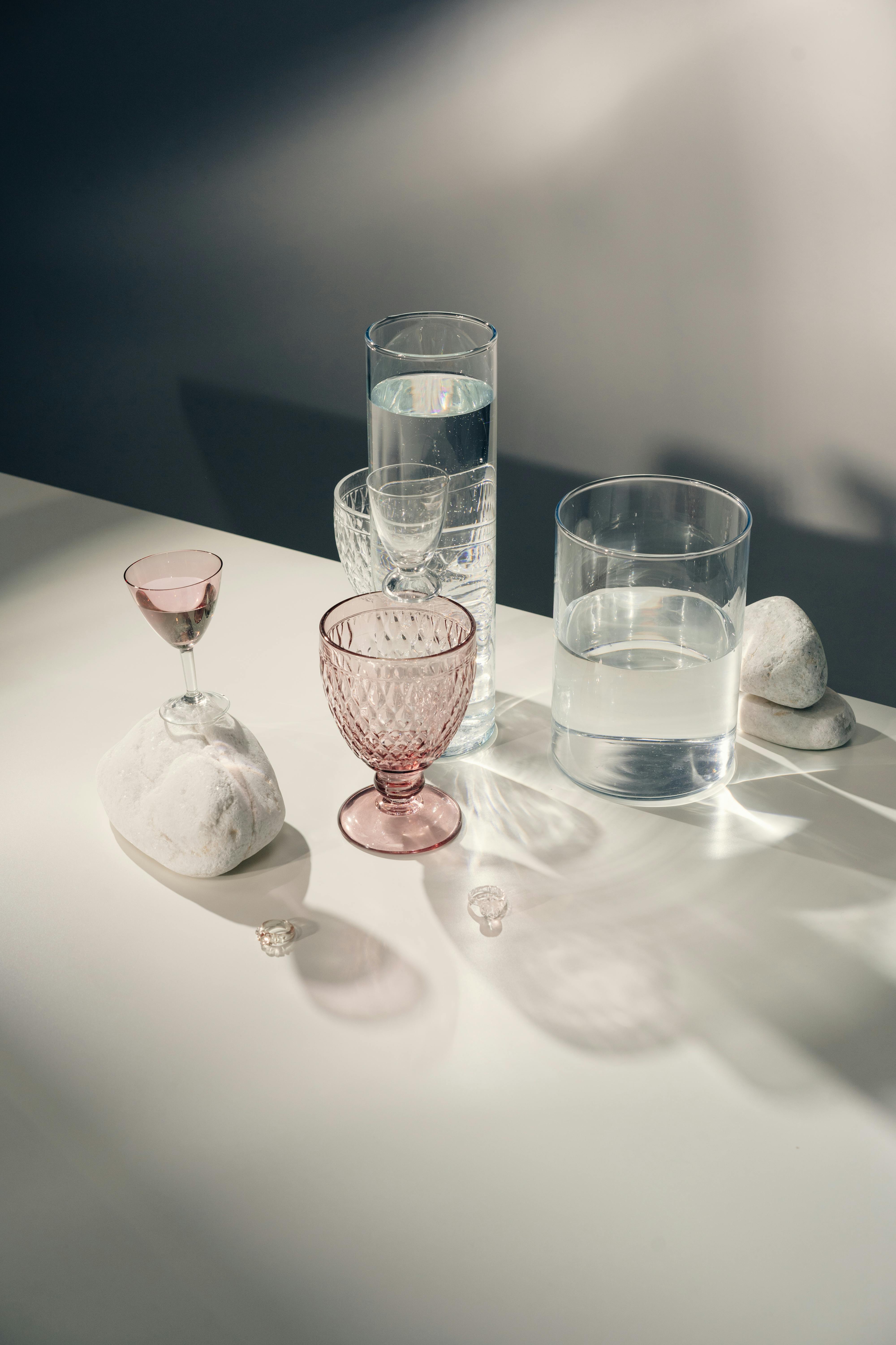 A minimalist arrangement of glassware casting elegant shadows on a tabletop.