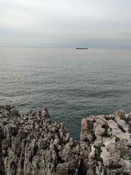 Free Captivating view of rugged cliffs meeting the vast ocean under a tranquil sky. Stock Photo