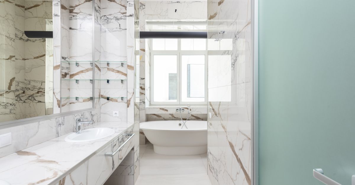 A stylish bathroom featuring a marble design and contemporary bathtub, ideal for luxury interiors.