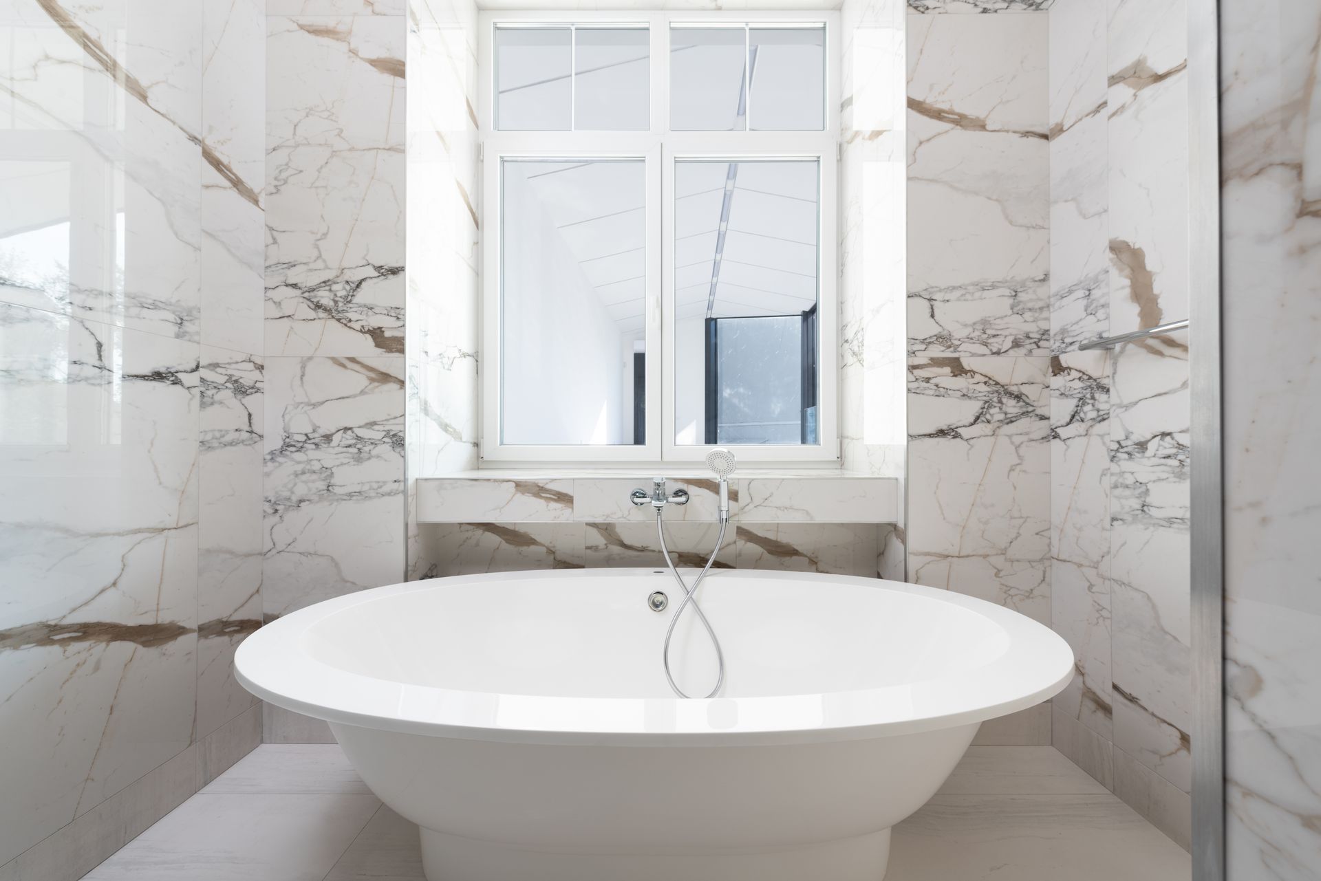Luxurious marble bathroom featuring a sleek freestanding bathtub and modern design elements.