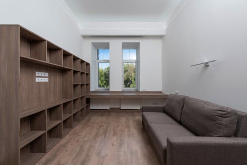 Brown Sofa Near Wooden Shelves