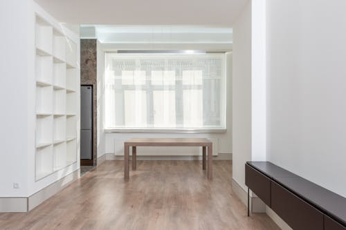 Brown Wooden Table Near the Glass Window