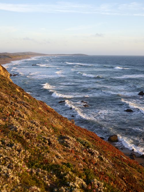Free A breathtaking coastal view with waves crashing on the rocky shoreline, creating a serene and majestic seascape. Stock Photo