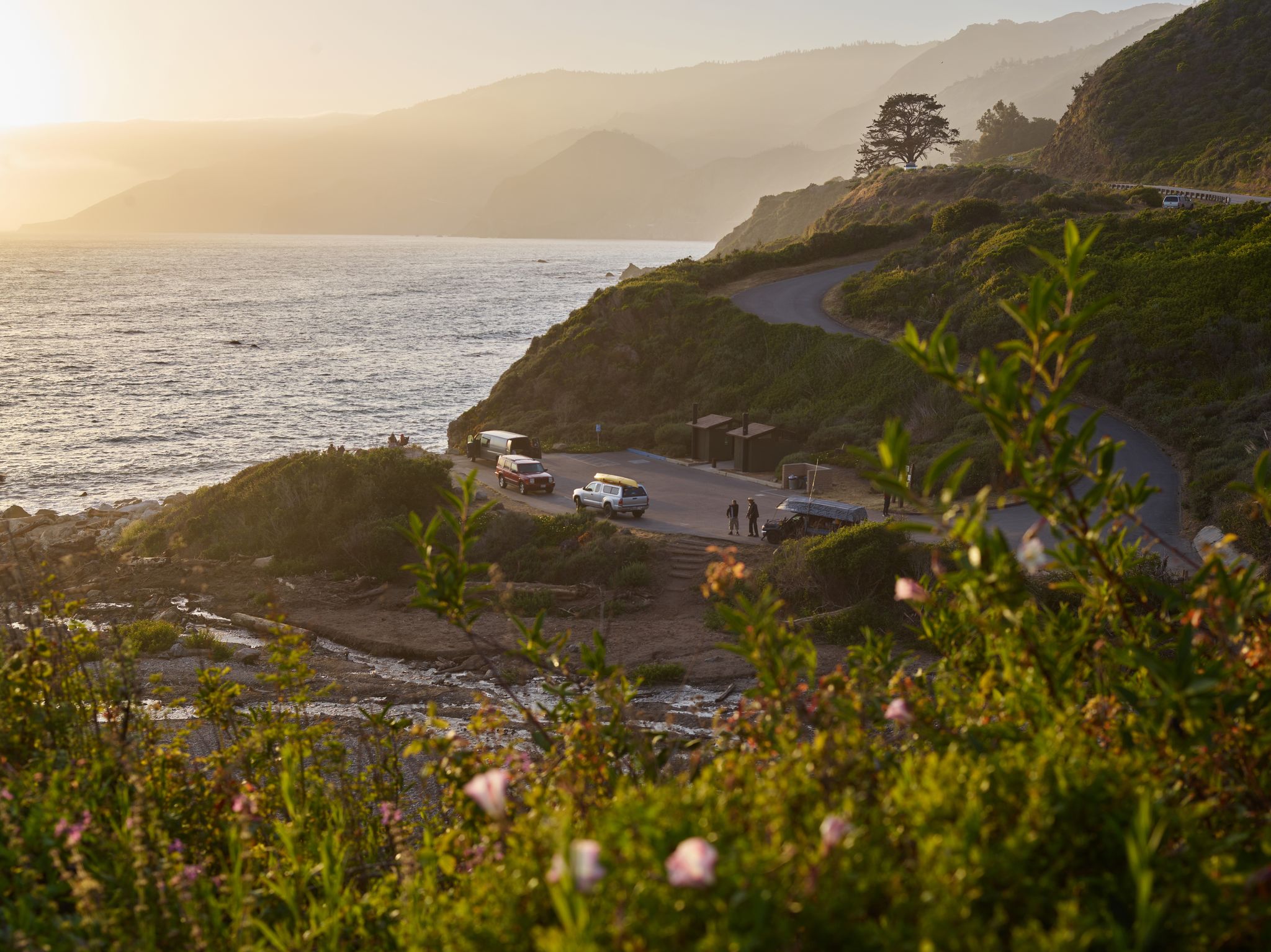 A coastal cliff road above the ocean at sunset.