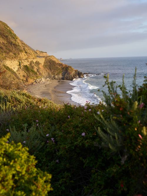 Free Beautiful coastal scenery with waves crashing on the shore and cliffs in the background. Stock Photo