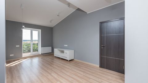 Bright and empty modern room with hardwood floors and large window view.