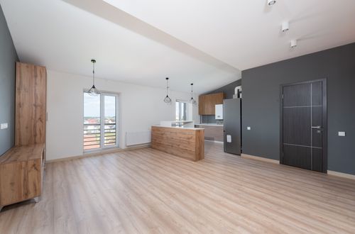 Free Spacious, bright, and empty open-plan kitchen and living area with wooden flooring. Stock Photo