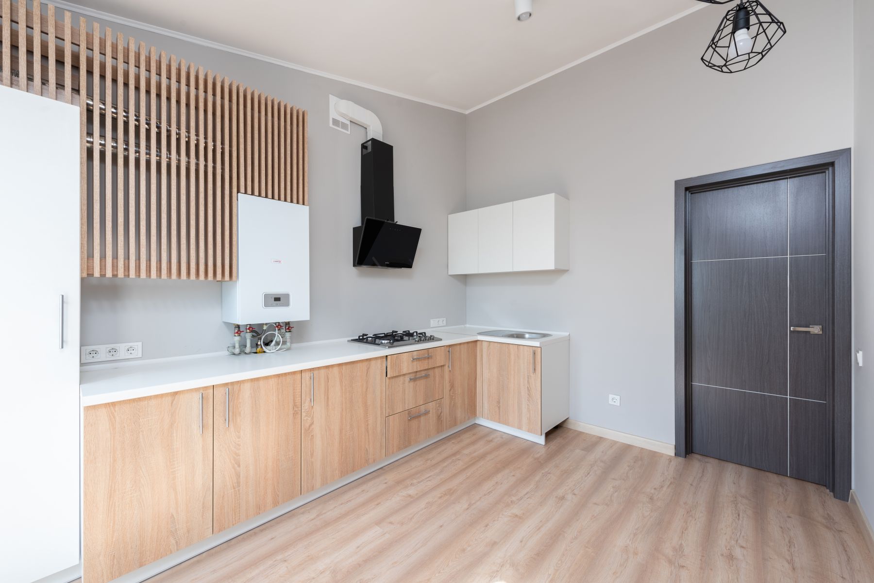 Simple wood base cabinets and white wall cupboards with a slatted wood panel
