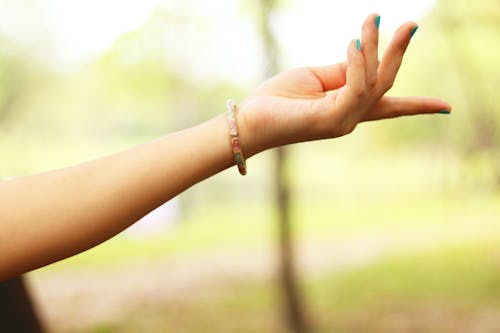 Close-Up Photography of Girl's Left Hand Wearing Bracelet