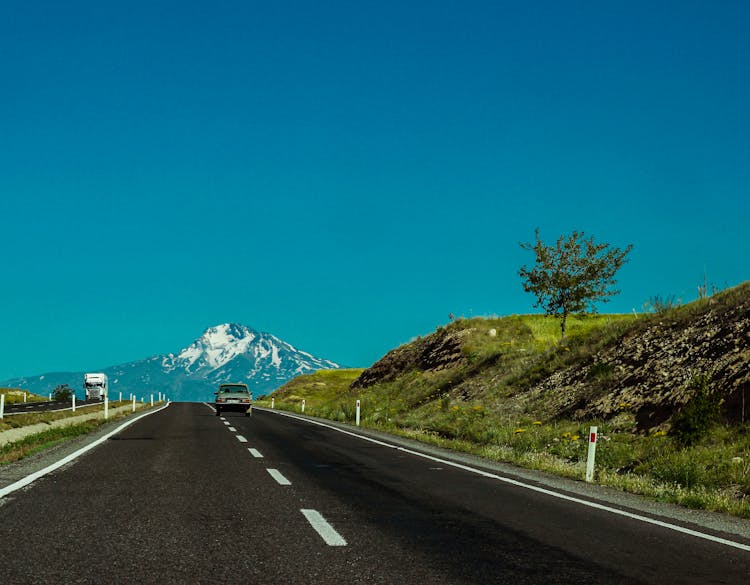 A Car And A Truck Driving On Countryside Roads