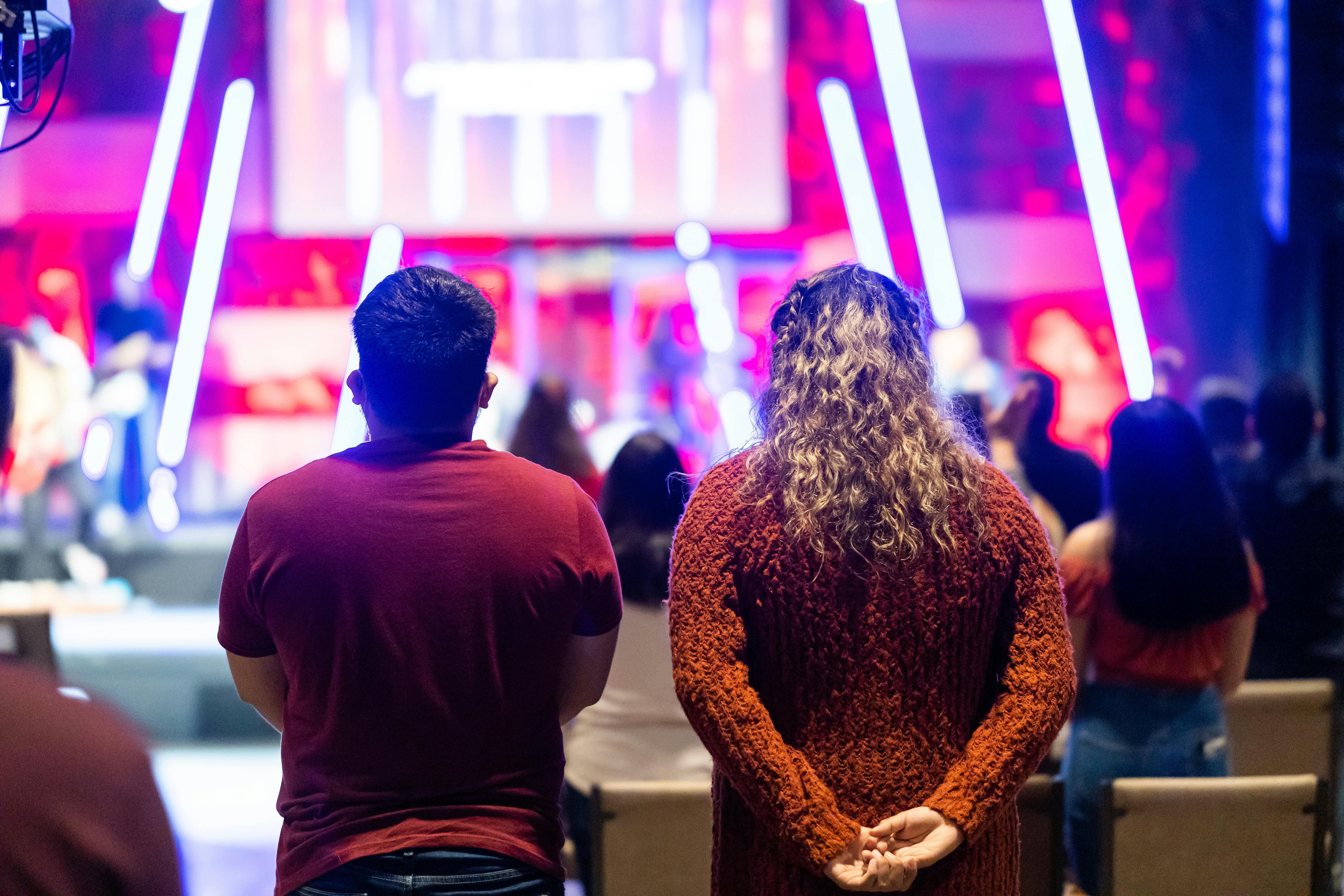 Free People attending a lively theater event with colorful neon lighting. Stock Photo