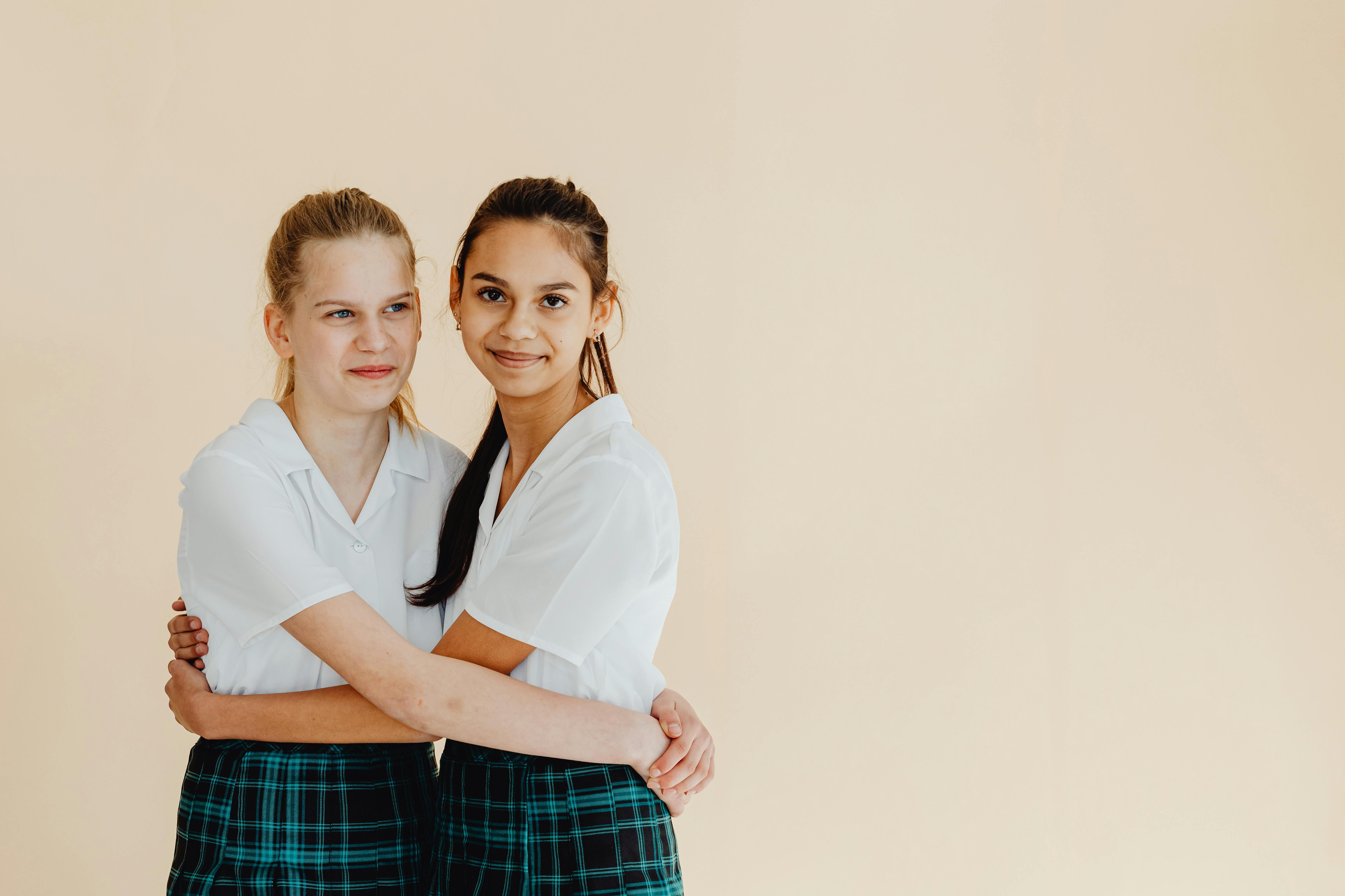 two women in school uniforms hugging
