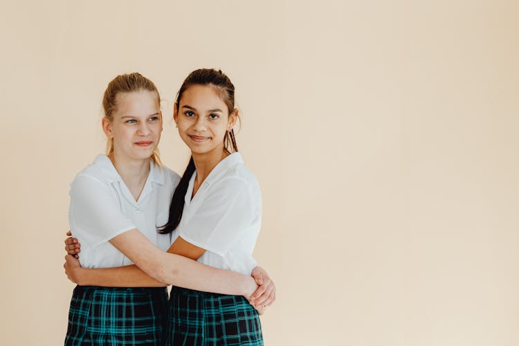 Two Women In School Uniforms Hugging