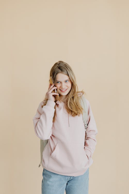 Free A Woman in Pink Sweater Talking on the Phone Stock Photo