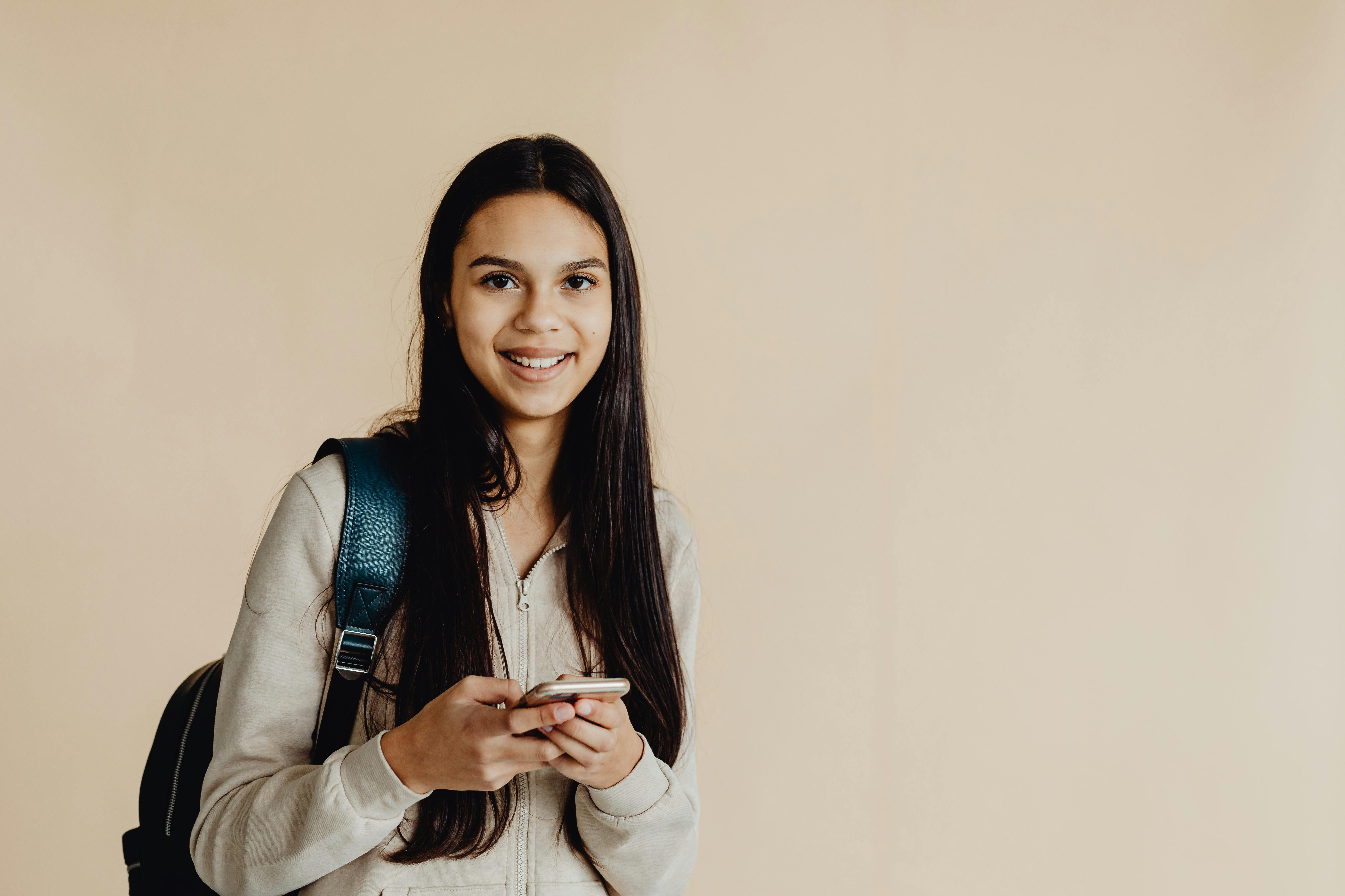 a woman in beige long sleeves holding a smartphone