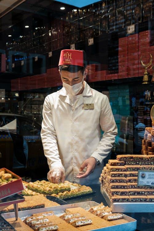 Free Young seller preparing sweets for sale in Turkish shop Stock Photo