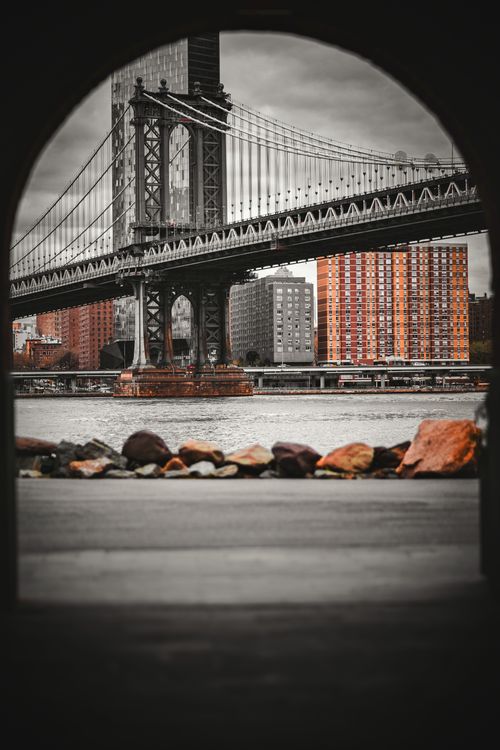 Free Framed view of the iconic Manhattan Bridge with city skyline backdrop. Stock Photo