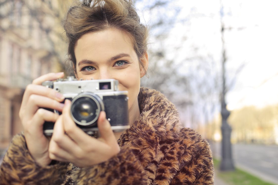 Mujer Sosteniendo La Foto De Enfoque De Cámara Negra Y Gris