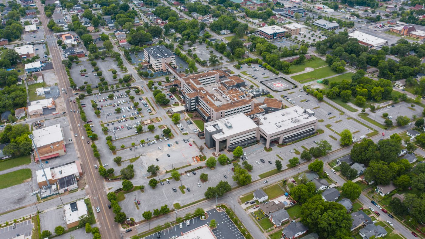 Aerial commercial market showing roads, businesses, parking areas, and surrounding communities