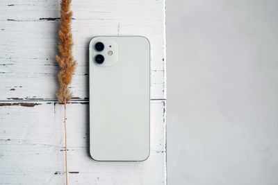 Phone resting on a pale wooden surface — photo by Vie Studio on Pexels