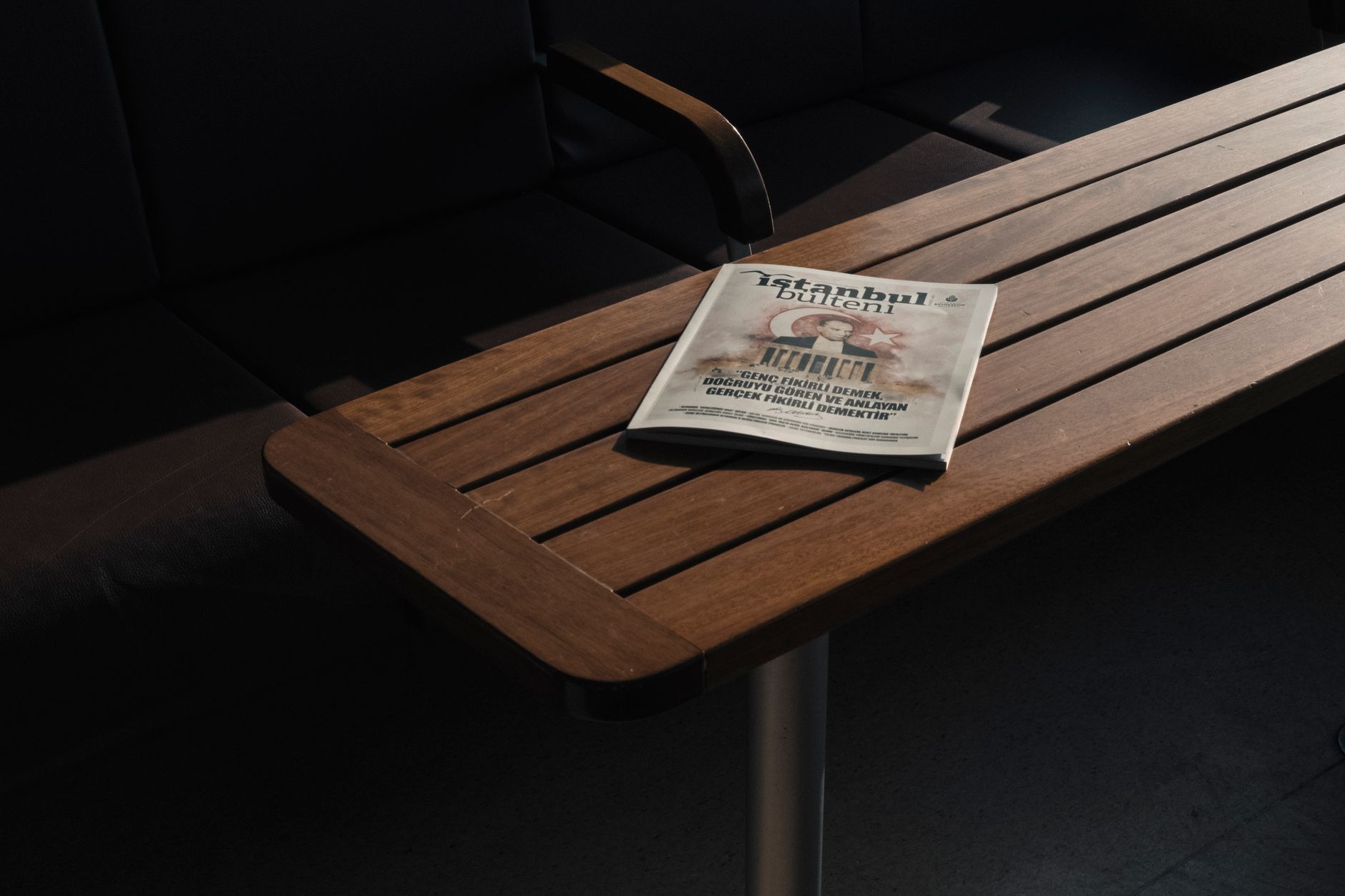 From above of empty dark chairs and closed book about Turkey placed on wooden dark brown table
