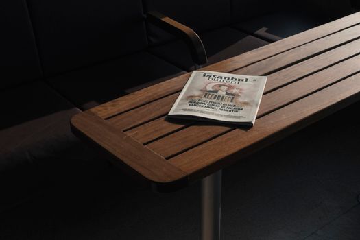 From above of empty dark chairs and closed book about Turkey placed on wooden dark brown table