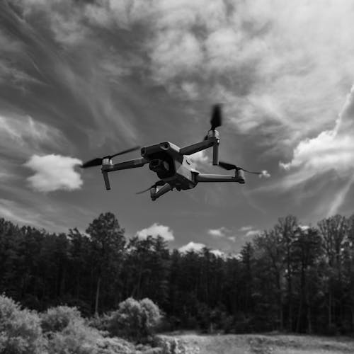 Grayscale Photo of a Flying Drone