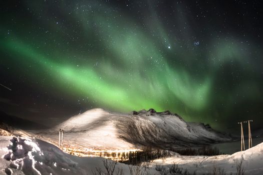 Stunning aurora borealis illuminating the night sky above snowy landscapes in Oslo, Norway.