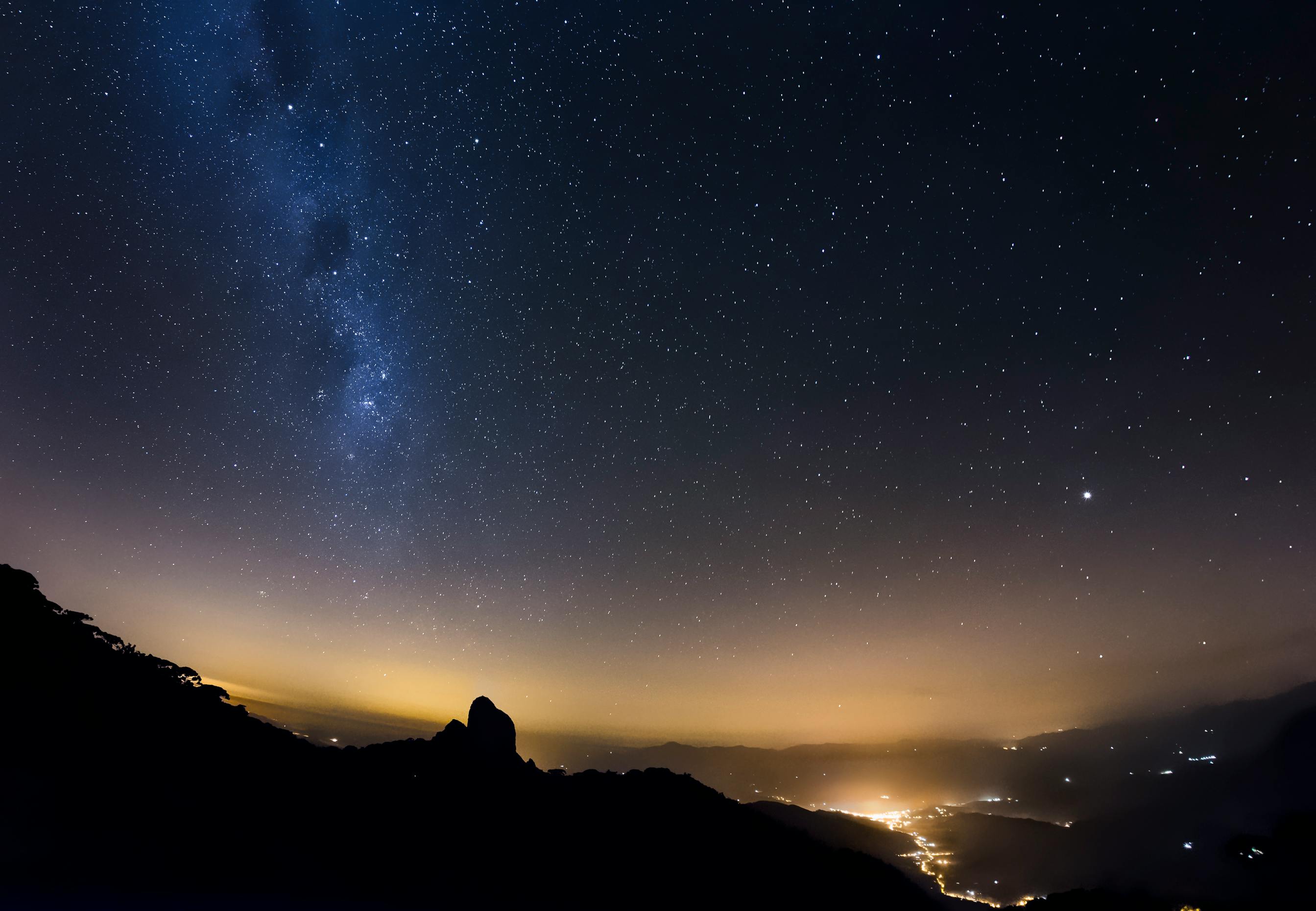 Spectacular view of a starry night sky and city lights from São Bento do Sapucaí, Brazil.