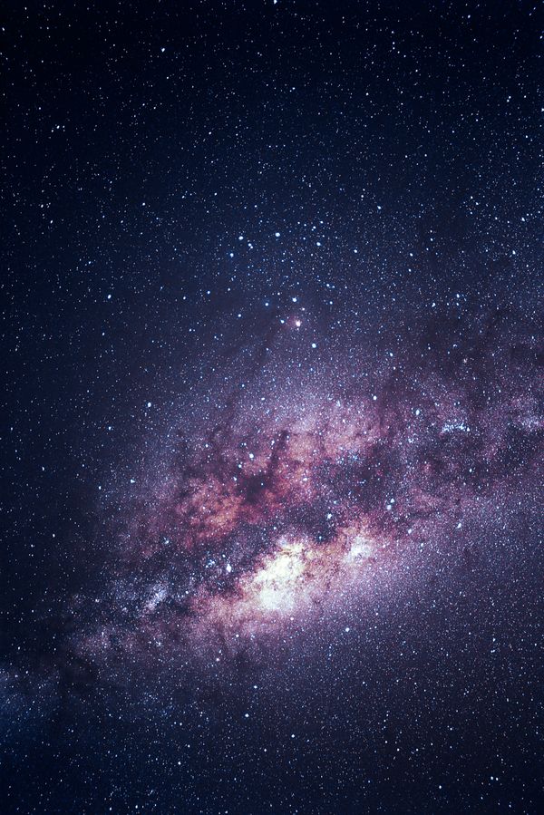 Captura deslumbrante da galáxia Via Láctea iluminando o céu noturno com estrelas e nuvens cósmicas.