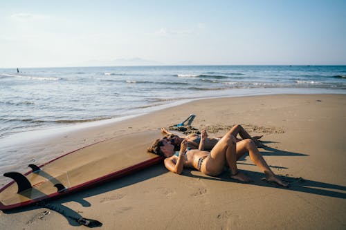 Photo of Women Laying on Seashore