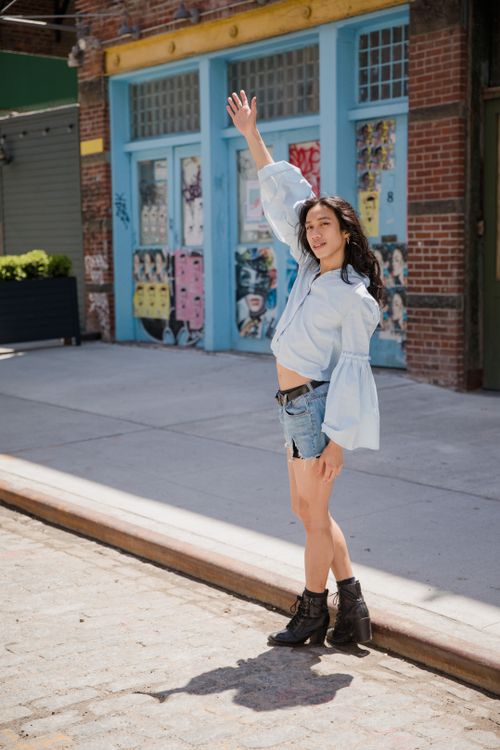 Free Casual street style with denim shorts and black boots in an urban setting. Stock Photo